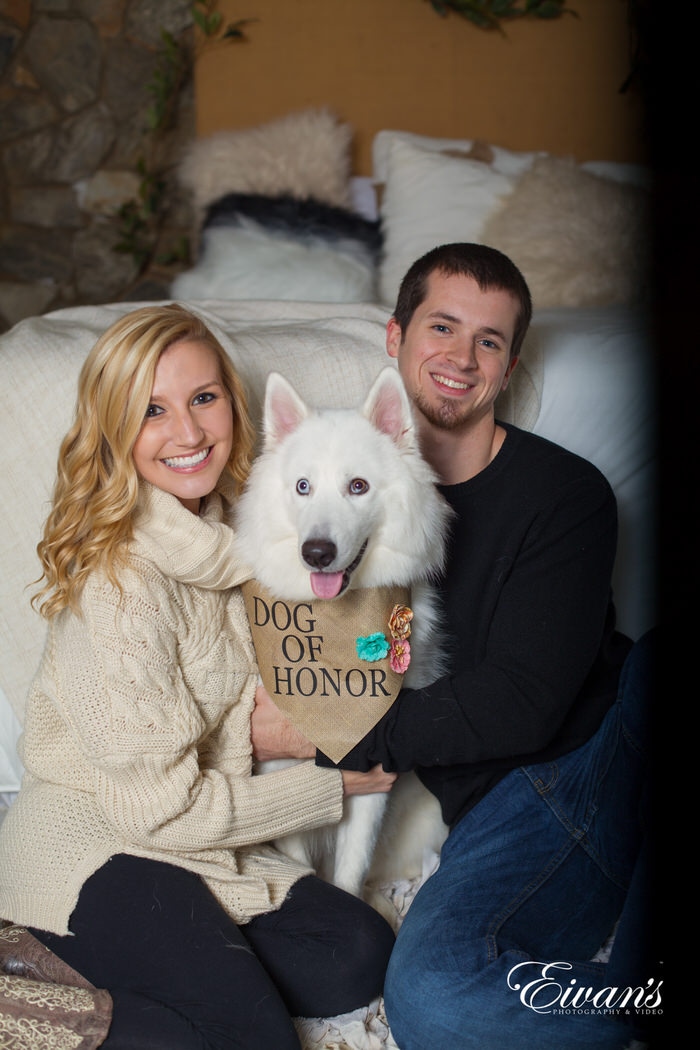 This couple holds onto their beloved dog of honor, simply smiling with all of the joy in the world.