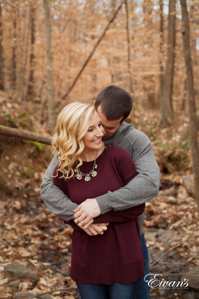 This loving embrace shared by this couple is almost as warm as the background of fall leaves and tremendously tall trees.