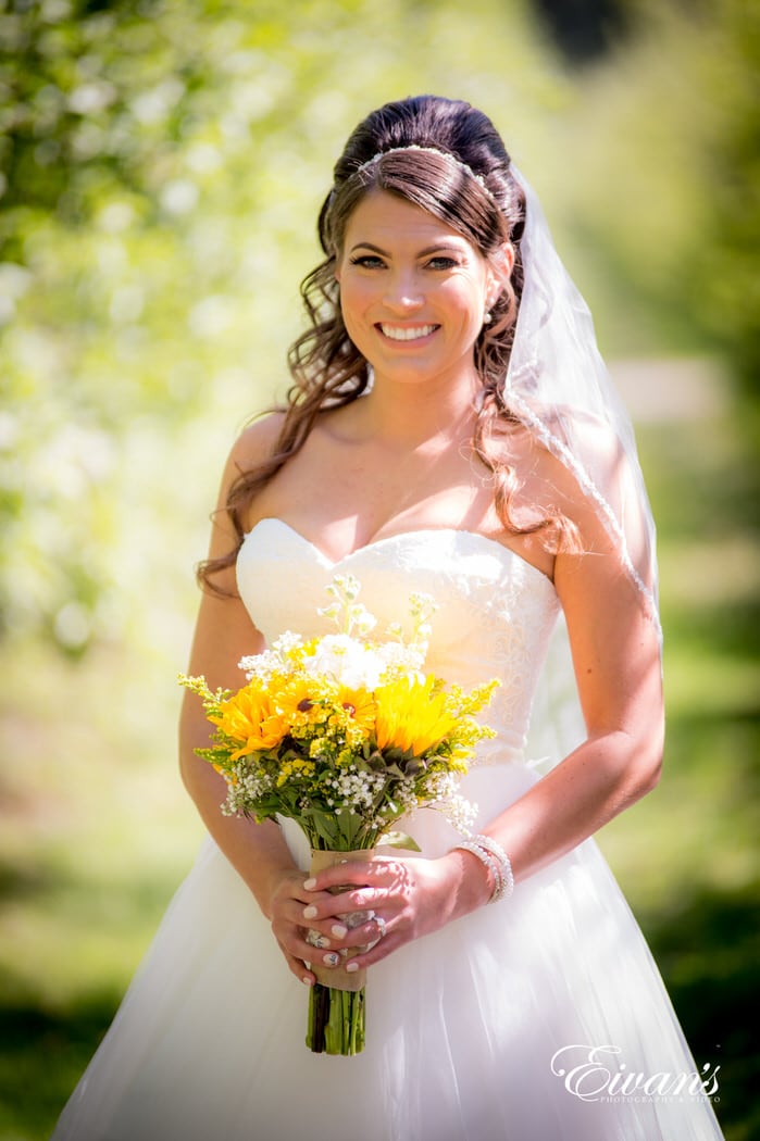 Standing in a beautiful meadow the bride looks absolutely stunning because of the definite contrast.