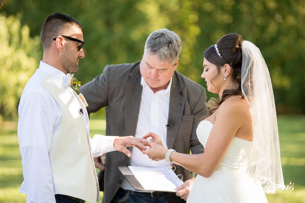 Slipping a ring onto the other's fingers the couple solidifies their vows and true love.