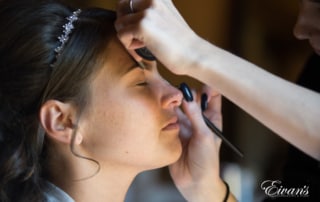 Applying the bride's makeup for her special day, she's preparing for the next major steps in her life.