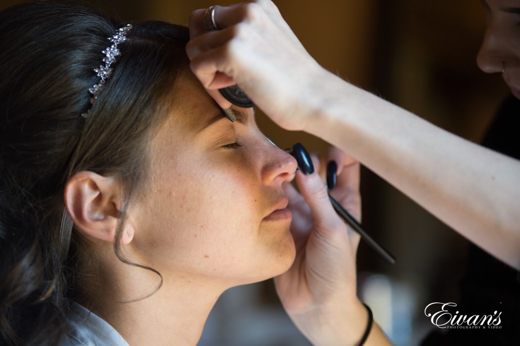 Applying the bride's makeup for her special day, she's preparing for the next major steps in her life.
