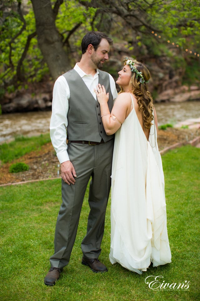 man in gray suit and woman in white wedding dress kissing