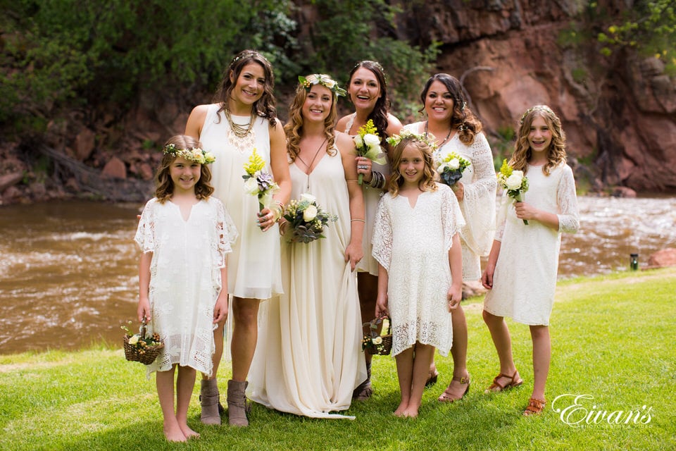 six women in white dresses standing on green grass field during daytime