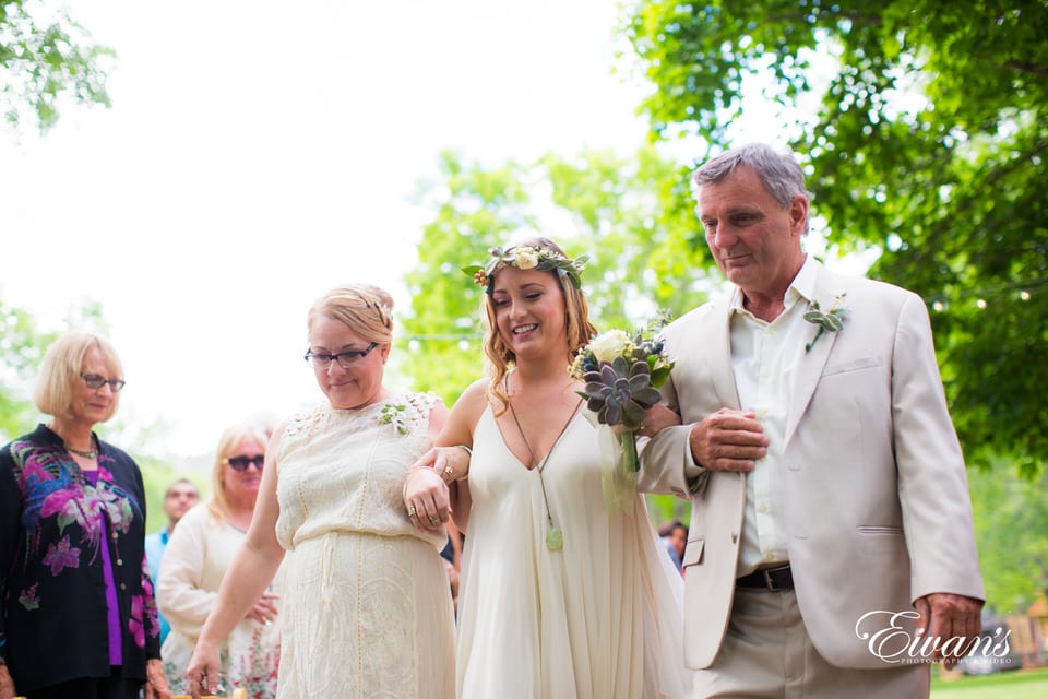 man in white suit standing beside woman in white sleeveless dress