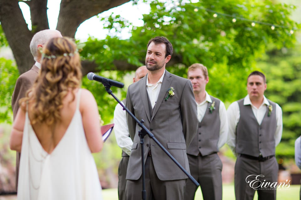 man in gray suit standing beside woman in white dress