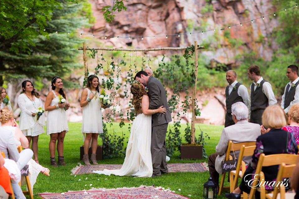 bride and groom standing on green grass field during daytime