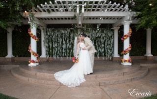 The bride and groom kiss at the top of the alter under an amazing decorative arch.