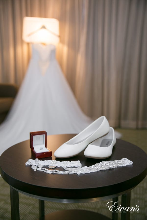 Amelia & Farron Gaerte The photographer focuses the camera lens on the bride's shoes, garter, bracelet and weddings ring in a depth of field shot.