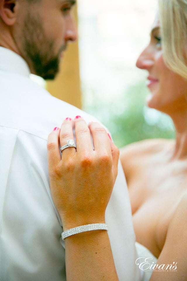 This wedding photographer makes the bride's ring a focal point while the newlyweds gaze lovingly at each other.