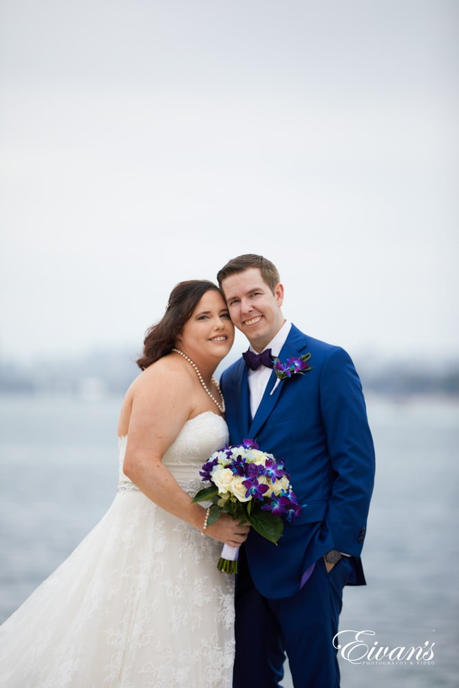 The bride and groom hold one another next to the beautiful shoreline.