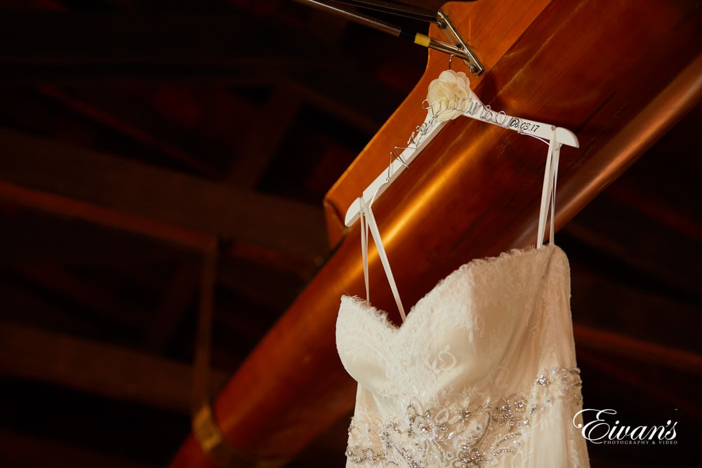 The hanger holding the bride's gown has her soon-to-be new last name.