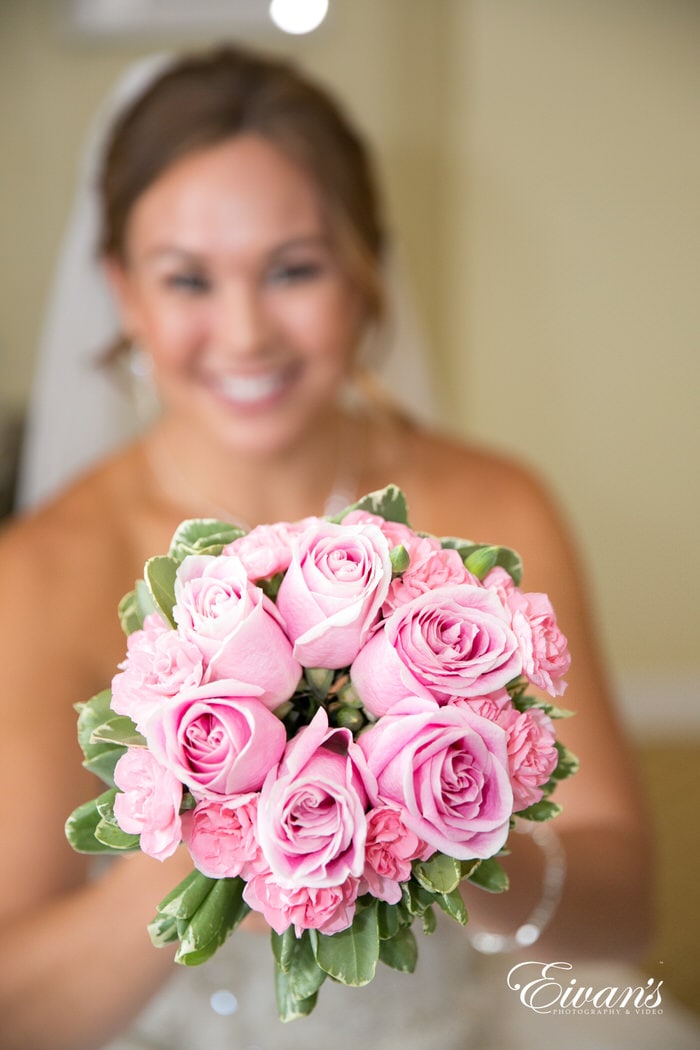 Chrissie smiles as she simply glows while holding her lovely bouquet of pink roses.