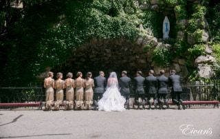 The couple and their counterparts kneel in front of a beautiful wall with lots of gorgeous ivy.