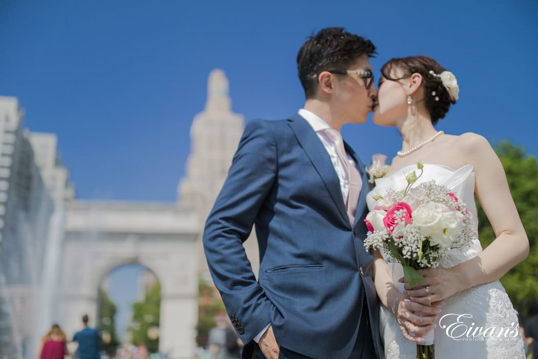 The groom and bride kiss and demonstrate their love in front of everyone and the gorgeous city