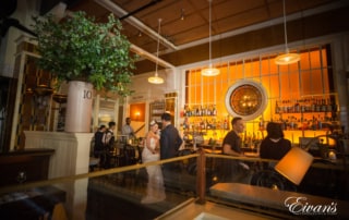 Sitting in a classic and modern bar the couple stay close to one another talking and celebrating their marriage.