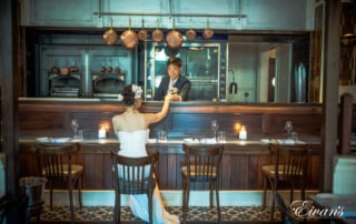 The groom serves a drink to the love of his life at a modern bar with a classic yet elegant twist.