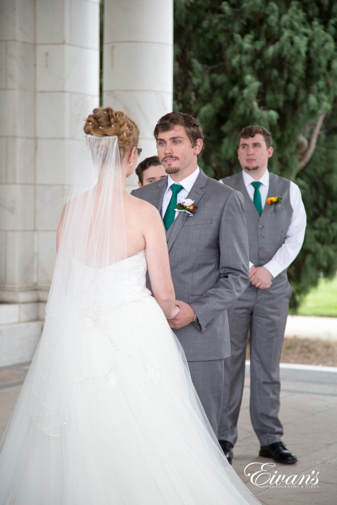 The bride and groom stand hand-in-hand sealing their vows and solidifying their love.