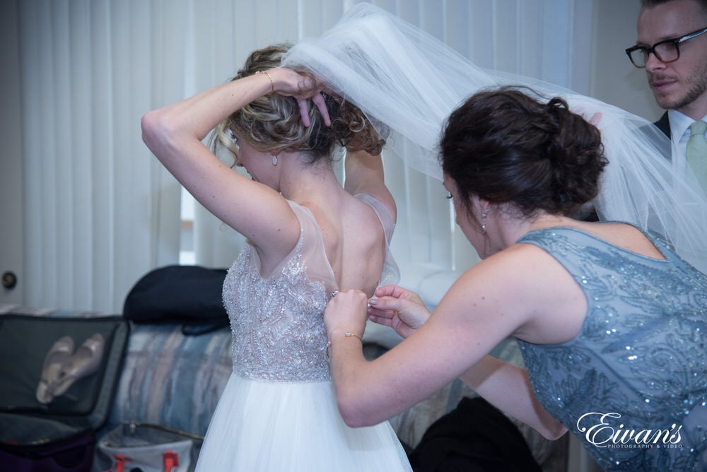 This is just as the bride has her dress being zipped and prepped for her walk down the isle.