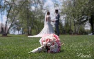 The bride and groom hold hands looking into one another's eyes.