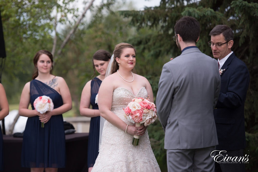 The bride beams into her groom's eyes as they seal their vows to one another.