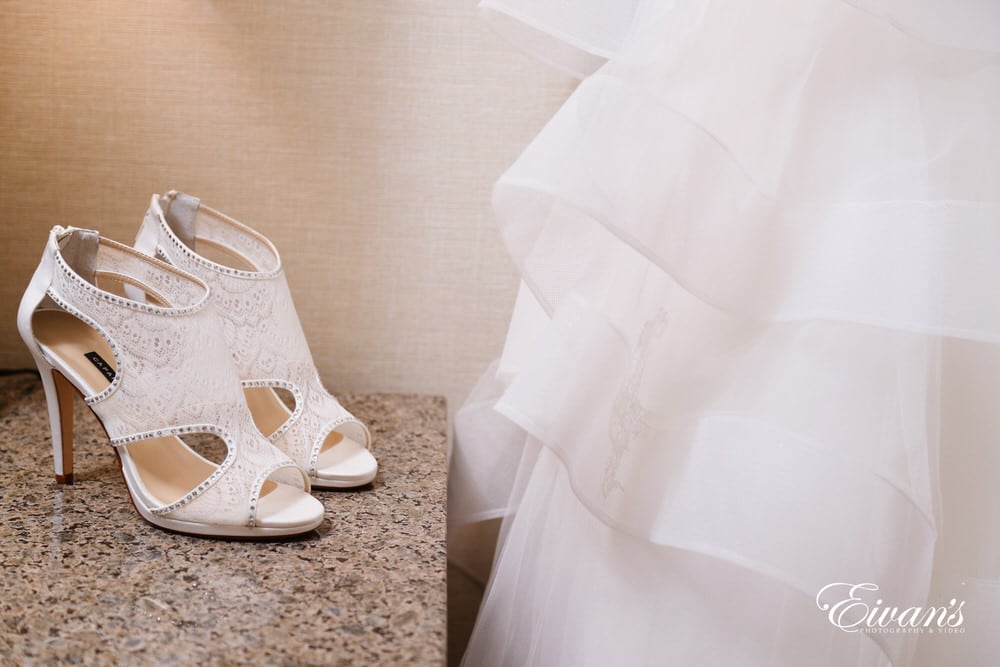 The bride's lace cream heels contrast the white flowing gown.