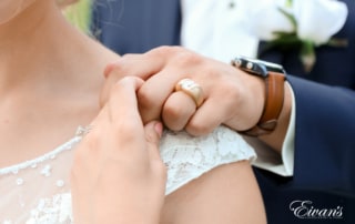 The bride and groom stand together while also showing off the new ring that will forever solidify their love.