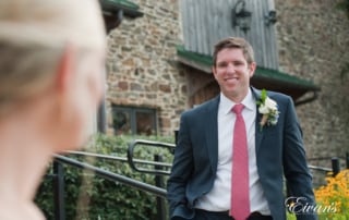 The groom gazes over at the love of his life and how absolutely stunning she looks.