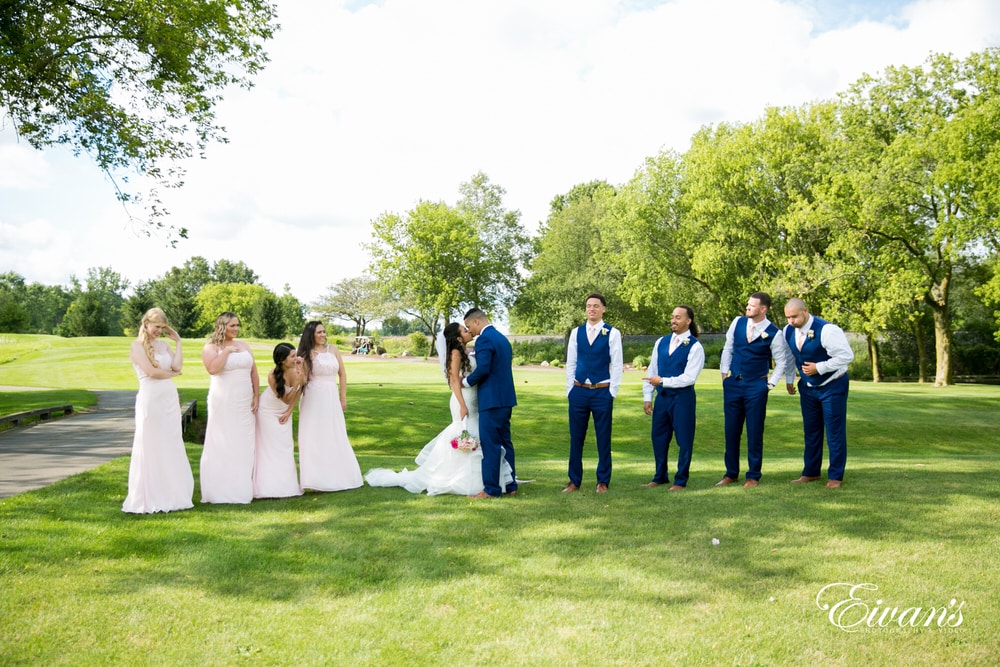 The bride and groom stand with their entire bridal party on such an amazing venue.