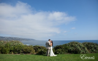 The bride and groom gaze over the beautiful hills into the dazzling blue ocean with all the promise of the world at their fingertips.