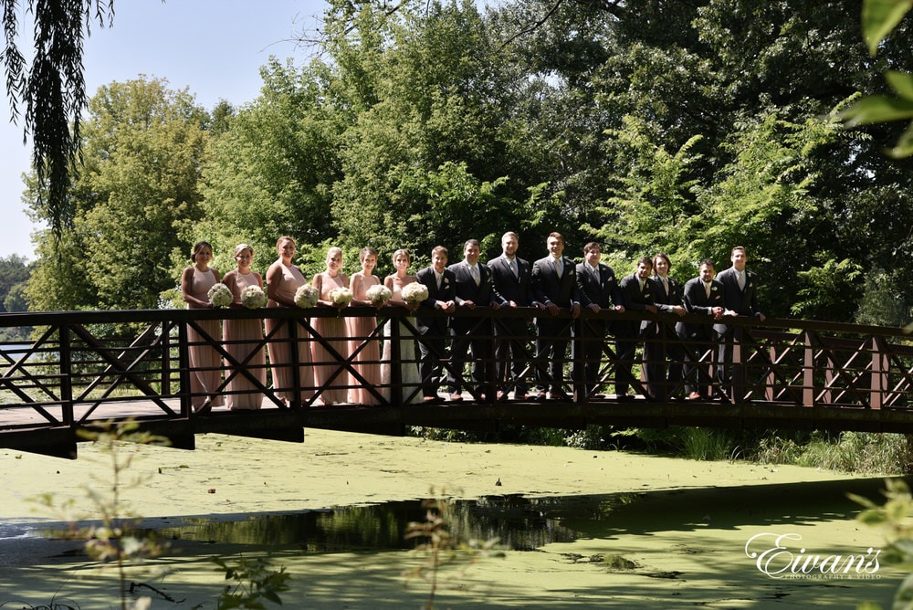 The entire bridal party stand beautifully together loving one another entirely.