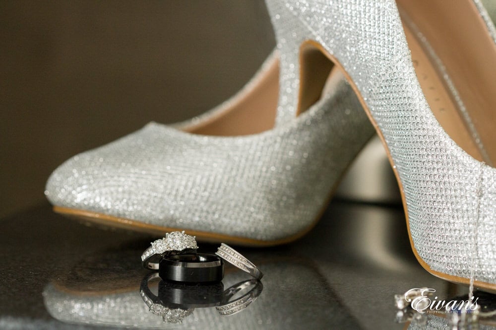 The couple's rings sparkle next to the bride's dazzling silver shoes.
