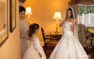 The bride fixes gown while also the bridesmaids and flower girl all prepare for such a tremendous affair.