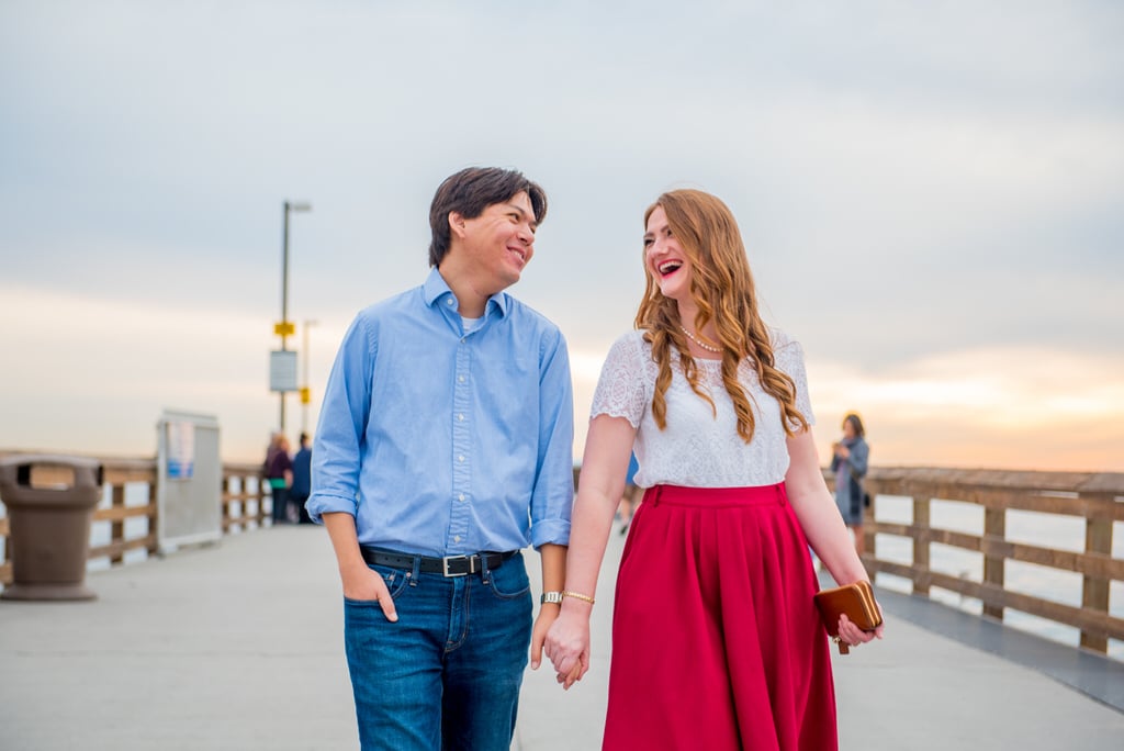 engaged man and woman walking side by side on the boardwalk