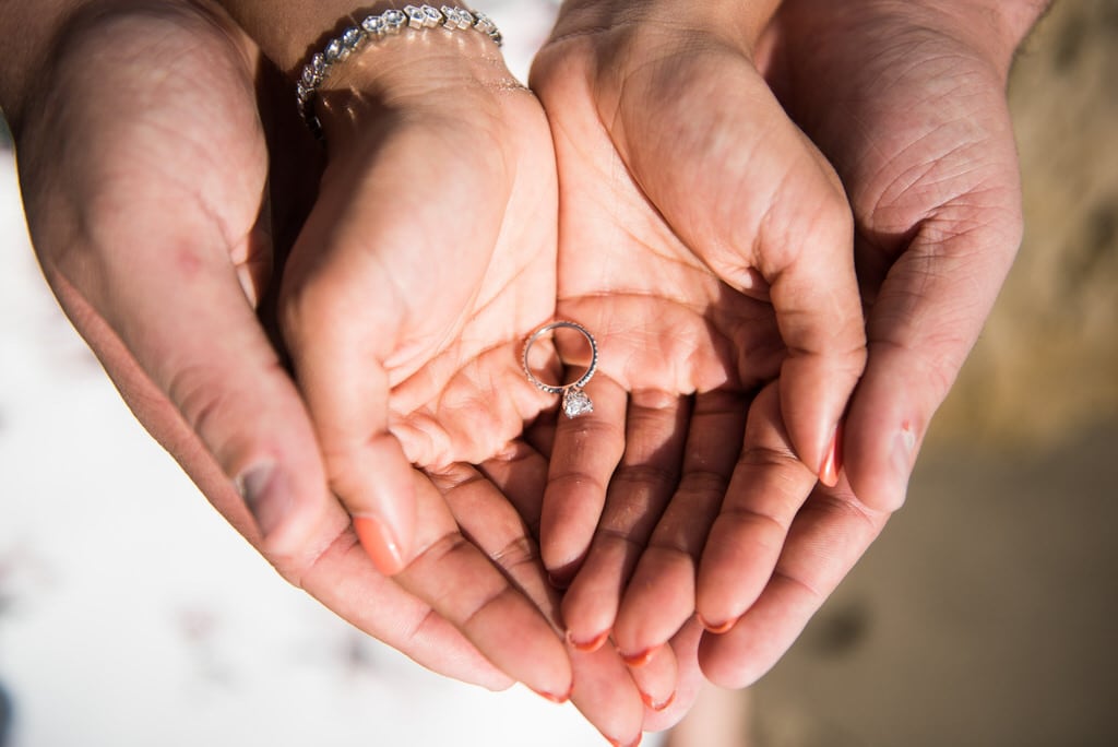 engaged man and woman holding the engagement ring