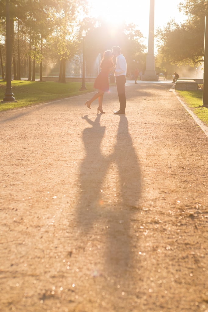 The beautiful sun is shining down on this couple as they demonstrate their love while walking along a gravel path. The sun radiating on this couple only gives this couple an eternal glow to develop their everlasting love.