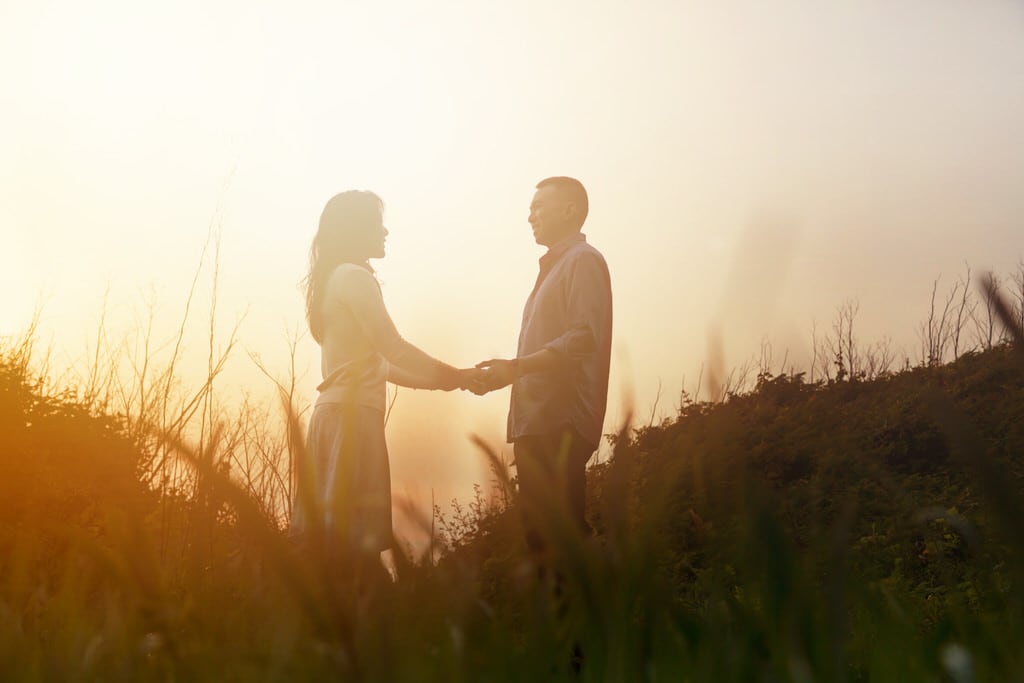 This warm sunset is not only captivating this couple's love but also representing a fire with such vivid colors.