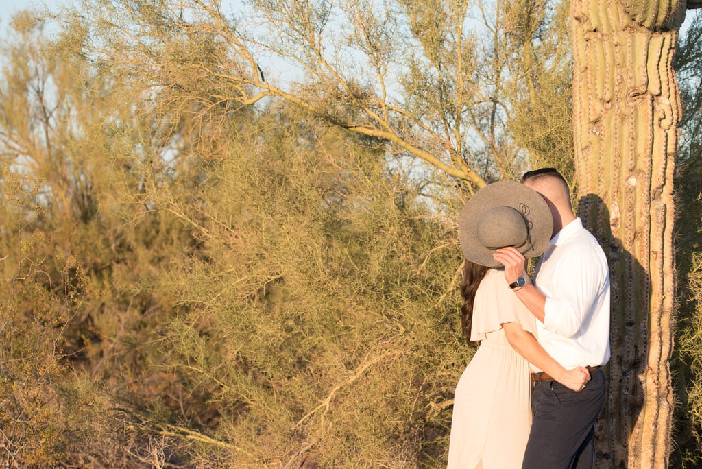 Behind the hat in the heat of the desert this couple not only showed their love but also kept it a little secretive by covering their kiss with the soon-to-be bride's sun hat.