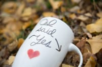eivans_gallery_engagement_photos_171 This fall photograph is personal yet also very romantic. There is a mug laying on a pile of soft yellow leaves with a handwritten message saying "I said Yes". That response was obviously associated with someone asking their true love to marry them.