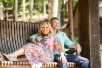 Shree & Bronson 8/12/17 A newly engaged couple sits on a bench with broad smiles and bright eyes on a sunny day.