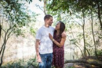 eivans_gallery_engagement_photos_174 A Young couple embraces one another in the middle of a forest area on a sunny day.