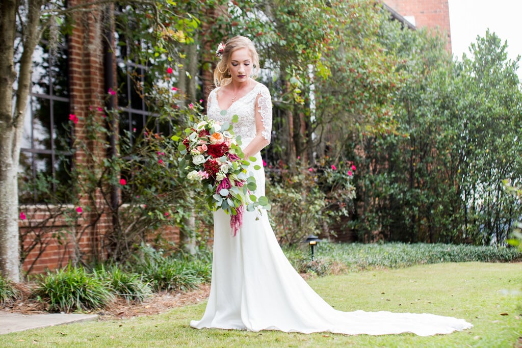 A gorgeous Bride carries her cascading bouquet on a stroll through the garden. The Bride is looking down, exposing her floral hairpiece and loose side-bun.