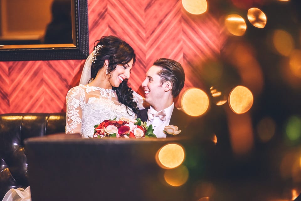 newlyweds sitting in a booth, minneapolis wedding photographer portfolio