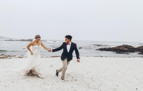newlyweds running on a beach, photographed by Eivan's in San Francisco