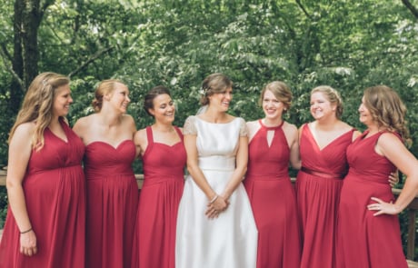 six women in red and white dresses standing near green trees during daytime