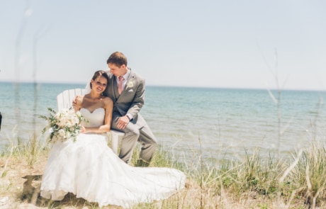 man and woman sitting on grass field near body of water during daytime