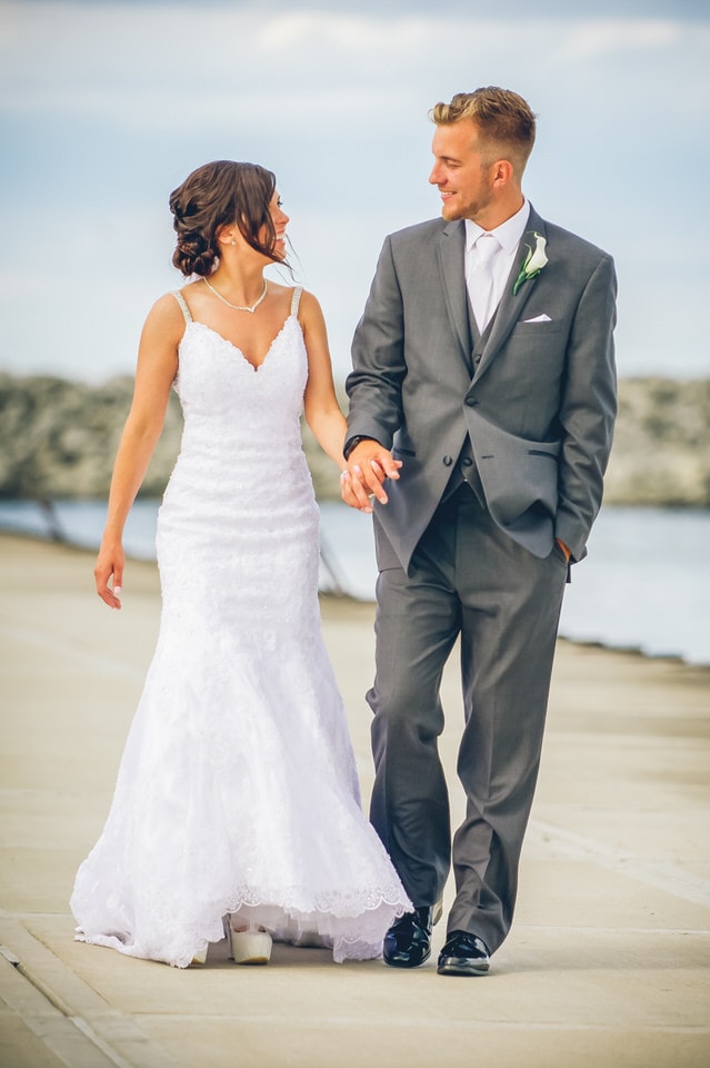 newlyweds strolling and holding hands, milwaukee wedding photographer availability