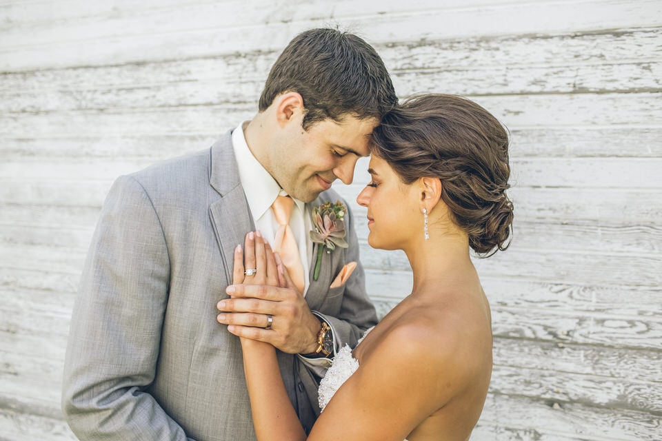 man in gray suit kissing woman in white floral dress