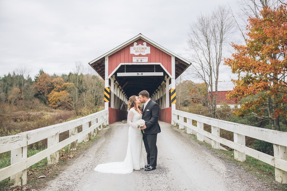 newlyweds kissing in front of a barn, pittsburgh wedding photographer availability
