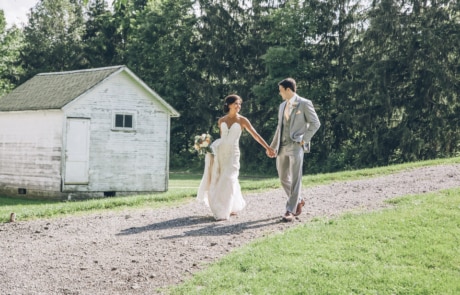man and woman holding hands while walking on green grass field during daytime